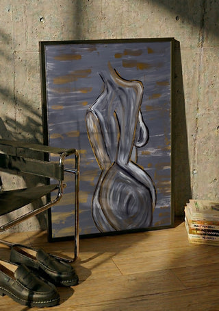 Contours of Silence by Bibi in a black frame leaning against a concrete wall by a steel chair