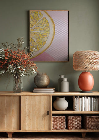 Lemon Slice by L.OE. Art above a wooden sideboard on a sage green wall