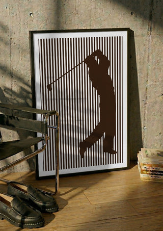 golf sport silhouette by nyai in a black frame leaning against a concrete wall by a steel chair