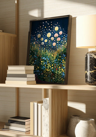 Meadow Under the Stars by Yokohama in a dark frame on a wooden shelf beside books and a lamp