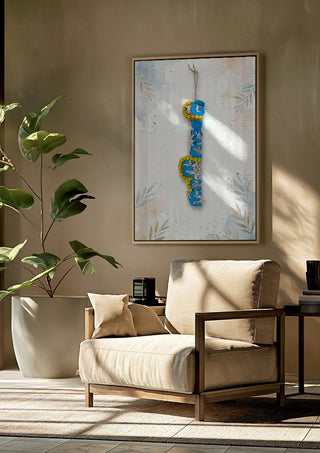 GREECE Terracotta by Ammar framed above a beige armchair beside a potted plant