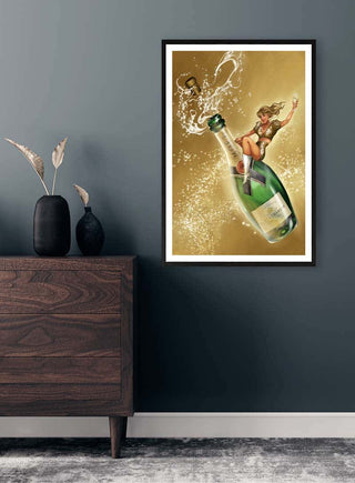 Framed "Bring Your Own Champagne" by Danii Steinfeldt displayed above a wooden dresser in a modern room.