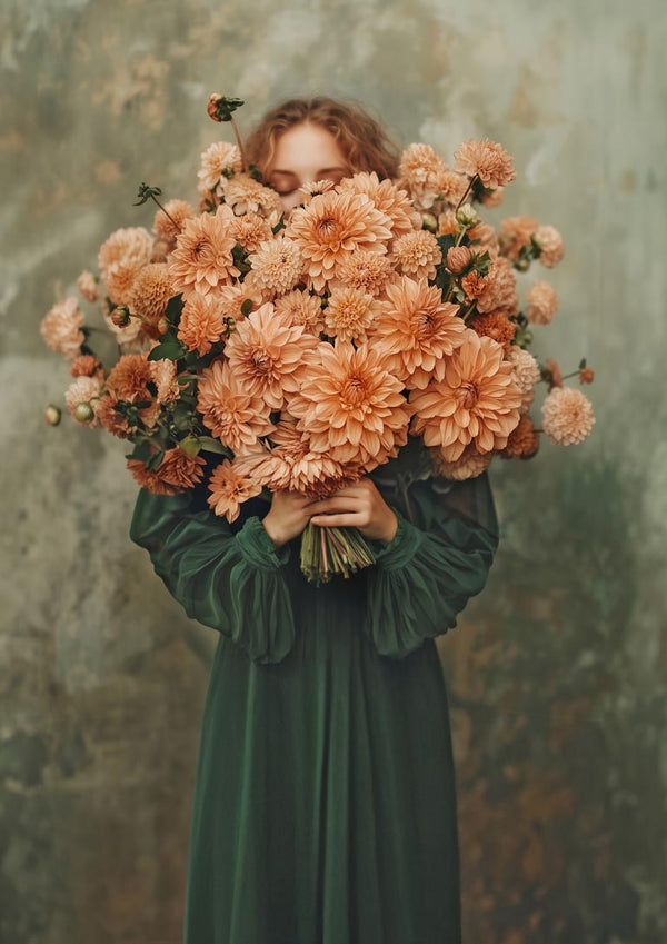 A woman in a green dress holds a large bouquet of peach flowers, partially covering her face.
