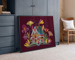 Whimsy Swedish Cottage Burgundy by Enikő Marosváry-Kramcsák framed and leaning against a wall