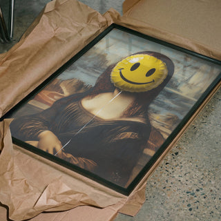 Framed parody of Mona Lisa with a smiley face balloon covering her face, unwrapped on the floor.