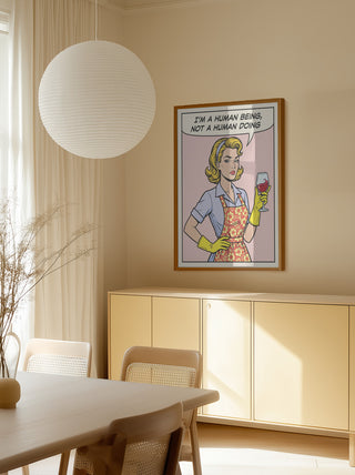 Framed "Human Being Pop Art" by Andreas Magnusson hanging above a modern beige sideboard in a bright dining room.