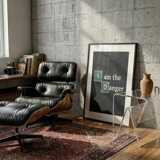 Framed "I am the Danger" science-themed print leaning against a concrete wall in a modern living room.