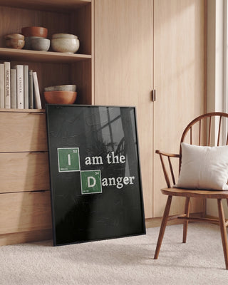 Framed "I am the Danger" science-themed print leaning against a cabinet in a cozy, modern room.