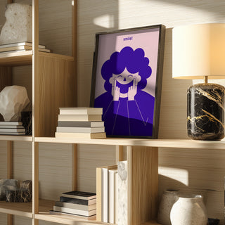 Framed "Big Happy Smile" print by Monika Gregulska on a wooden shelf with books, decor, and a lamp.