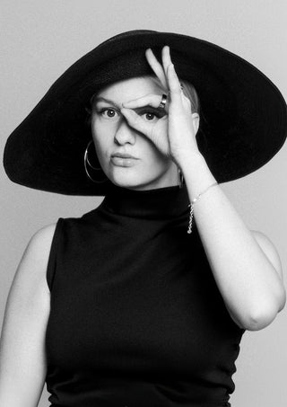 Back in time by Bettinafloorphoto - a black and white portrait of a woman in a wide-brimmed hat framing her eye with her hand