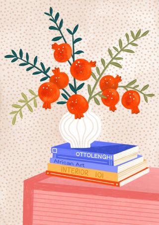 Cozy Tabletop Pomegranates by Bea Müller – pomegranate branches in a white vase on stacked books