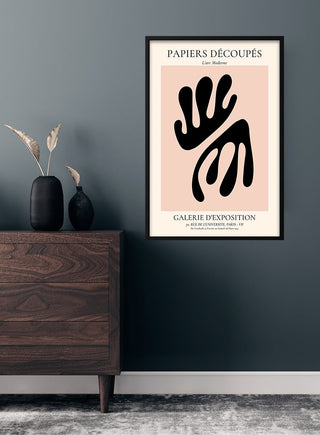 French Art Inspired black coral on pink poster with abstract shapes, framed and hung above a wooden dresser.