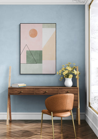 Wall art with pastel minimalist shapes above a wooden desk, styled in a modern home office setting.