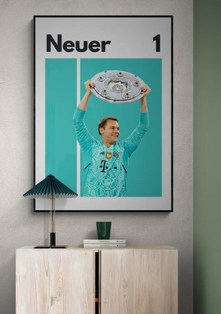 Manuel Neuer holding a trophy with "Neuer 1" text, featured on a football poster above a cabinet.